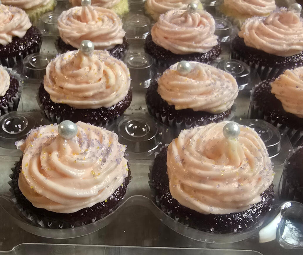 Homemade chocolate cupcakes with swirled vanilla frosting and pearl sprinkles
